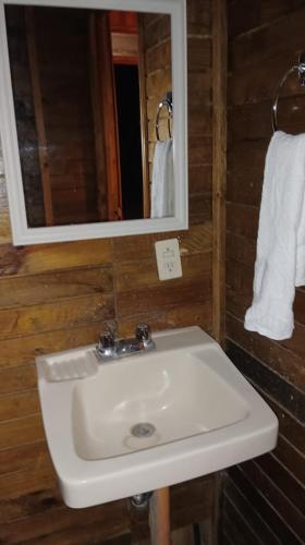 a bathroom with a sink and a mirror and towels at Villa Atitlan in Panajachel