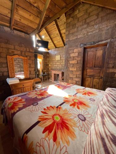 a bedroom with a large bed with a flower blanket at La Casa del Abuelito in San Miguel Regla