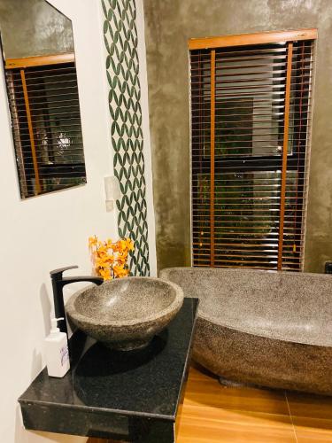 a bathroom with a large stone sink on a counter at Moloppor Villa in Battambang