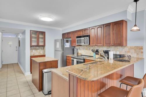 a kitchen with wooden cabinets and a counter top at Shipwatch 115C by Wild Dunes, Oceanfront Condo in Isle of Palms