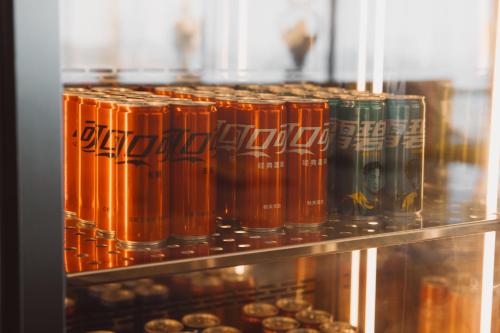 a row of orange soda cans on a shelf at 青岛海天大酒店 山海相拥典雅奢华 in Qingdao