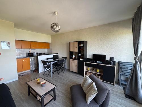 un salon et une cuisine avec un canapé et une table dans l'établissement Biscarrosse Plage: T2 avec Terrasse, Parking, Face Océan - FR-1-319-200, à Biscarrosse-Plage
