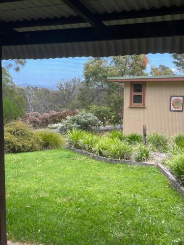 a yard view from the porch of a house at Kangarutha Cottage - Escape to Nature just minutes to Tathra in Kianinny