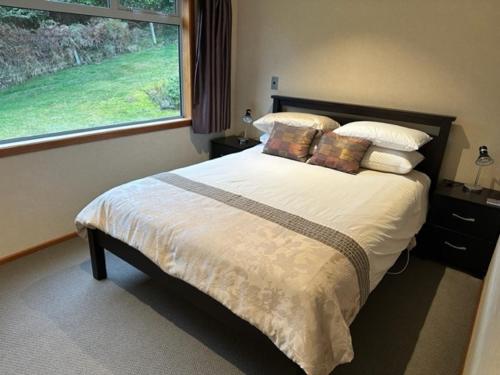 a bedroom with a large bed with a window at Spacious Home with a Lake View in Taupo