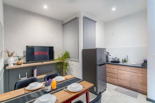 a kitchen and dining room with a table and a refrigerator at Neu Suites KL with Daily Breakfast Included in Kuala Lumpur