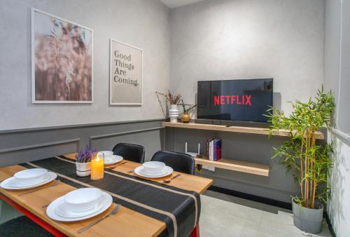 a dining room with a table and a tv at Neu Suites KL with Daily Breakfast Included in Kuala Lumpur