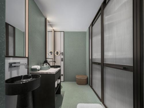a bathroom with a black sink and a mirror at FU VALLEY Hotel in Liyang