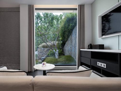 a living room with a large window with a tree outside at FU VALLEY Hotel in Liyang