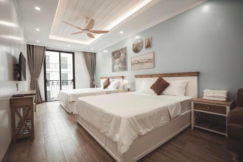 a bedroom with two beds and a ceiling fan at Samson Soleil Hotel in Sầm Sơn