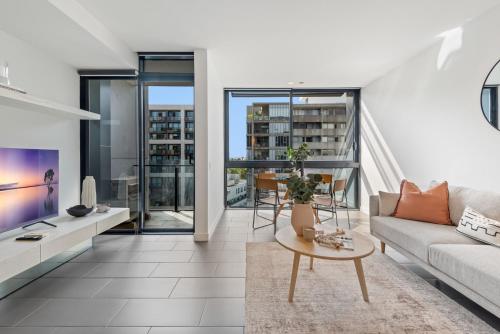 a living room with a couch and a table at Chic City Escape with Pool, Gym & Parking in Melbourne