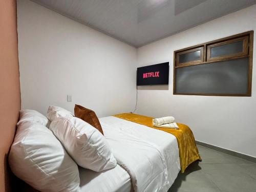 a bed in a room with a sign on the wall at Apartamento Carmelina-solo a dos cuadras del parque in Carmen de Viboral