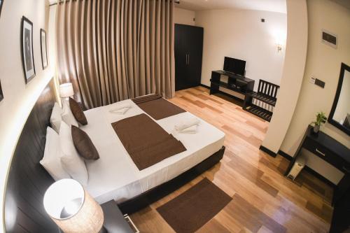 a bedroom with a large white bed and a piano at Hiriketiya Beach Resort in Hiriketiya