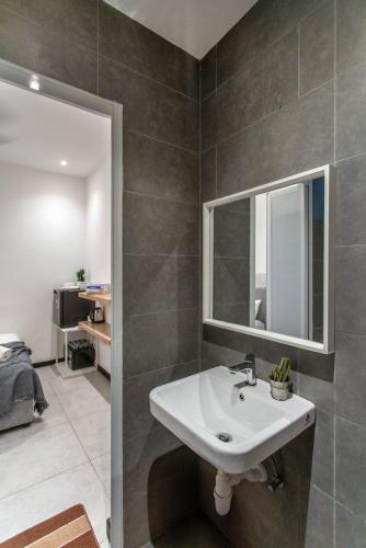 a bathroom with a sink and a mirror at Neu Suites KL with Daily Breakfast Included in Kuala Lumpur