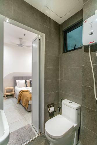 a bathroom with a toilet and a bedroom with a bed at Neu Suites KL with Daily Breakfast Included in Kuala Lumpur