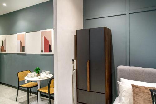 a room with a table and chairs and a bed at Neu Suites KL with Daily Breakfast Included in Kuala Lumpur