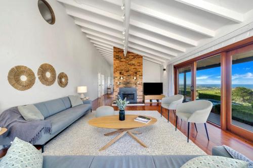 a living room with a couch and a table at Saddleback Grove Kiama in Kiama