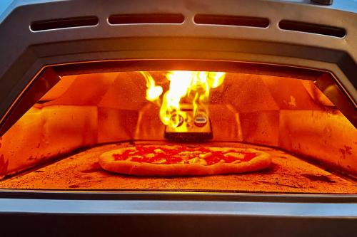 a pizza is being cooked in an oven at Saddleback Grove Kiama in Kiama