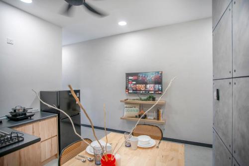 a kitchen with a table and two chairs and a tv at Neu Suites KL with Daily Breakfast Included in Kuala Lumpur