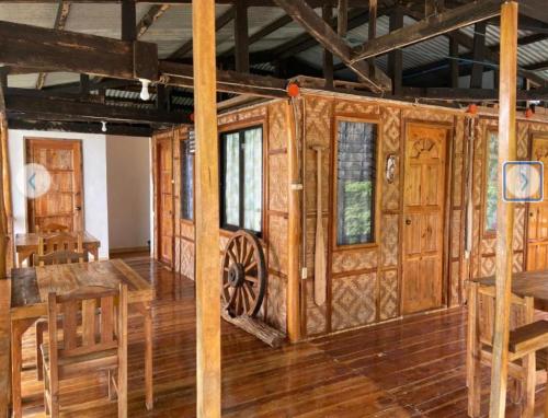 a room with wooden walls and a wooden table and chairs at Rio Beach Resort in Alegria