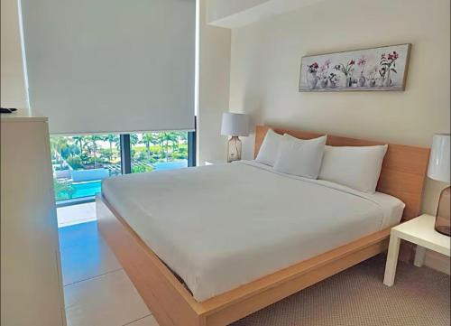 a large white bed in a room with a window at Down Town Doral 1b in Miami