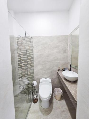 a bathroom with a toilet and a sink at Paraiso Coveñas, Unidad con la mejor piscina in Coveñas