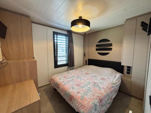 une petite chambre avec un lit et une fenêtre dans l'établissement Chalet 2 chambres proche plages et Canal du Midi - FR-1-783-47, à Agde
