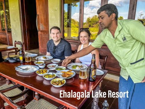 un gruppo di persone sedute attorno a un tavolo che mangiano cibo di Ehalagala Lake Resort a Sigiriya