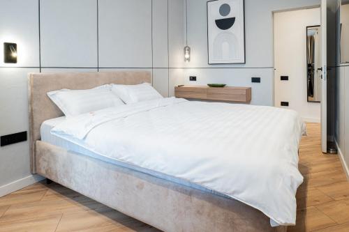 a bedroom with a large bed with white sheets at CHANTTAL Luxury - AMZEI in Bucharest
