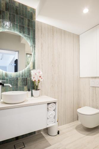 a bathroom with a sink and a toilet and a mirror at CHANTTAL Luxury - AMZEI in Bucharest