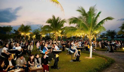 a crowd of people sitting in chairs at a party at Fivitel Nam Hoi An Riverside in Thuận An
