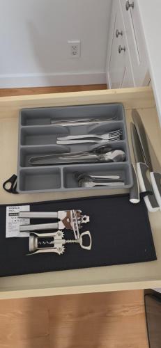 a drawer filled with knives and other kitchen utensils at New Royal Inn in New Westminster