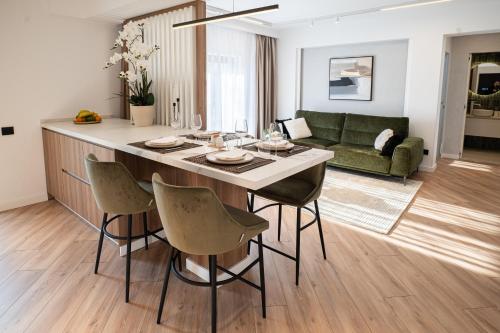 a kitchen and living room with a table and chairs at CHANTTAL Luxury - AMZEI in Bucharest