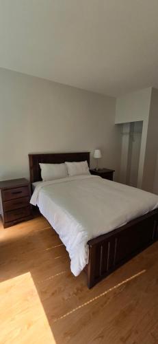 a bedroom with a large bed and a wooden floor at New Royal Inn in New Westminster