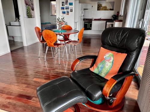 a living room with a chair and a table at Sunrise on Falie Seaview Eco Accommodation in American River