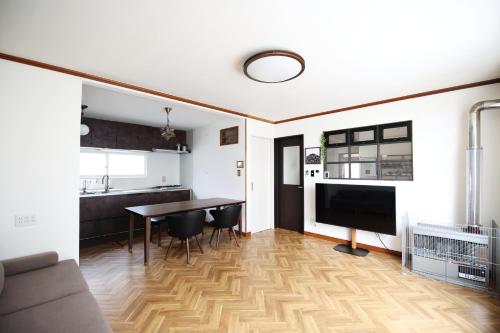 a kitchen and living room with a table and chairs at Ayumi STAY 駐車1台のみ in Sapporo