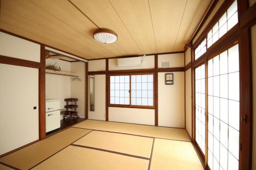 an empty room with windows and a room with a kitchen at Ayumi STAY 駐車1台のみ in Sapporo