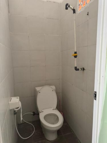 a small bathroom with a toilet and a pipe at Santai Guesthouse Balangan in Uluwatu