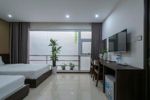a bedroom with a bed and a tv and a window at COCO Tuan Chau Hotel in Ha Long