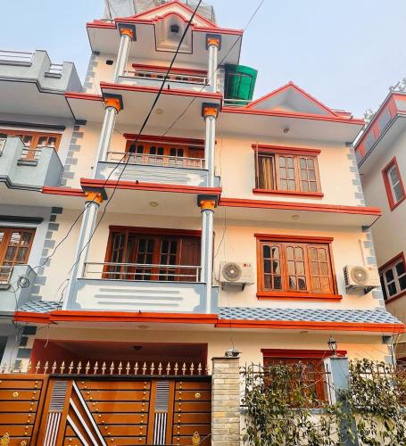 a tall white building with orange windows at Ansum Retreat in Bālāju