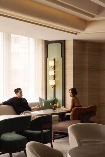 a man and woman sitting at a table in a room at Capella Taipei in Taipei