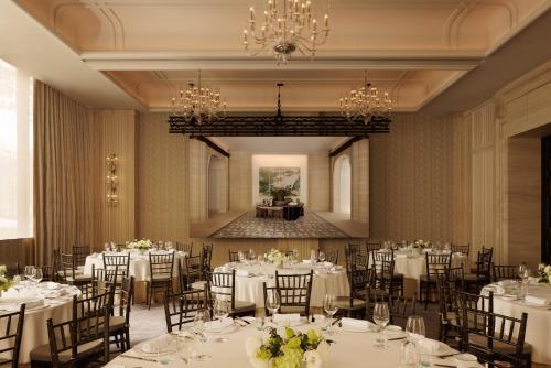 a banquet room with white tables and chairs and a chandelier at Capella Taipei in Taipei