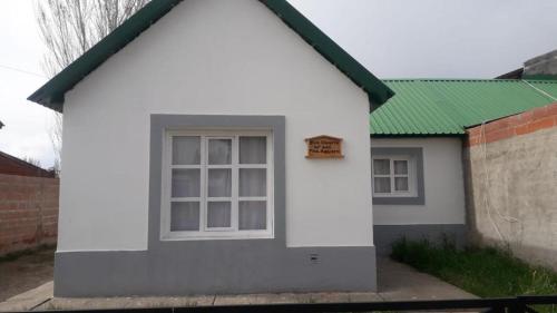 a small white house with a green roof at Casa familiar en Los Antiguos in Los Antiguos