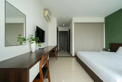 a bedroom with a bed and a desk and a television at COCO Tuan Chau Hotel in Ha Long