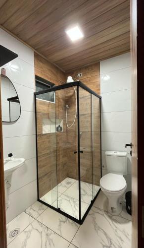 un bagno con doccia in vetro e WC di Flats Rota dos Corais a São Miguel dos Milagres