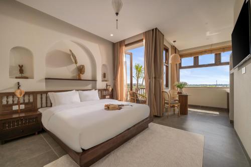 ein Schlafzimmer mit einem großen Bett und einem großen Fenster in der Unterkunft Poetic Riverside Villa - Steps to Hoi An Night Market in Hoi An