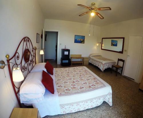 a bedroom with two beds and a ceiling fan at Sea View Sirolo di Amedeo in Sirolo