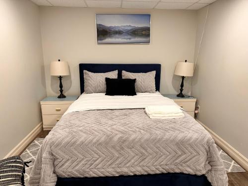 a bedroom with a large bed with two lamps at 1 bed in-home mini apartment in Dieppe in Dieppe