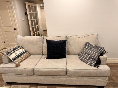 a couch with pillows on it in a living room at 1 bed in-home mini apartment in Dieppe in Dieppe