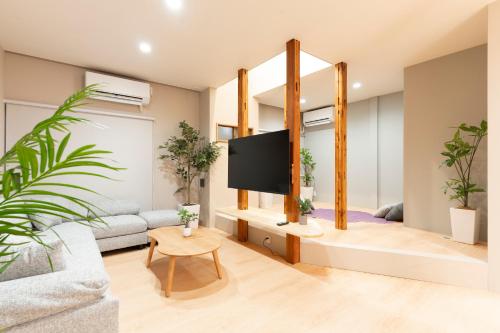 a living room with a tv and potted plants at 凪ノ家曳舟 Naginoya Hikihune in Tokyo