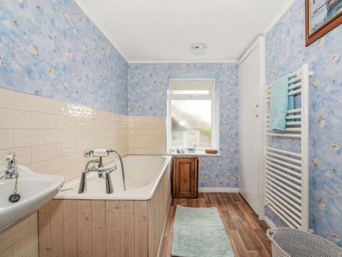 a bathroom with a tub and a sink at Duck Cottage in Bridlington